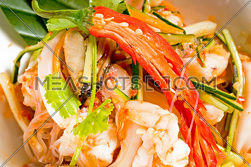 fresh seafood thai style salad with glass noodles on a bowl close up