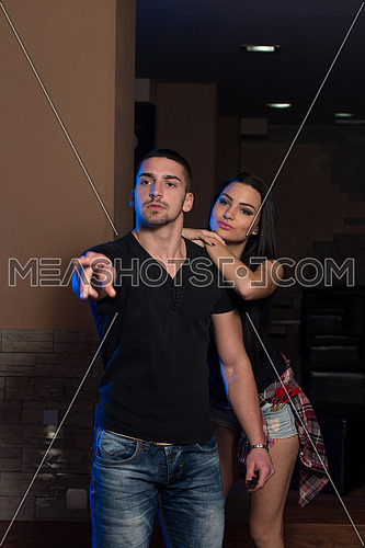 Young Couple Playing A Game Shooting Darts