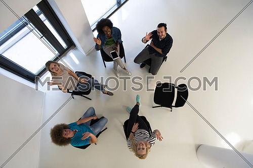 Multiethnic startup business team on meeting in modern bright office interior brainstorming, working on laptop and tablet computer top view