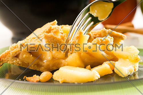 fresh homemade apple pie over green glass dish macro colseup eating  with fork
