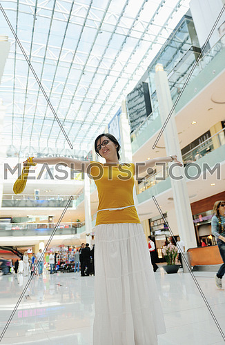 happy young woman shopping in big modern city mall