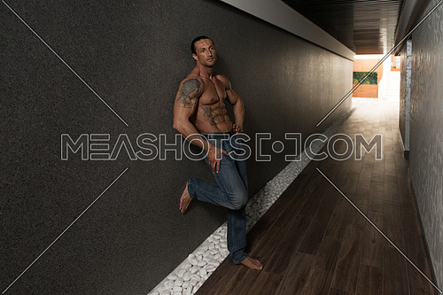 Portrait Of A Muscular Mature Man In The Modern Corridor Where He Poses