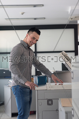 young business man copy documents on copy machine at modern startup office interior, casual clothes