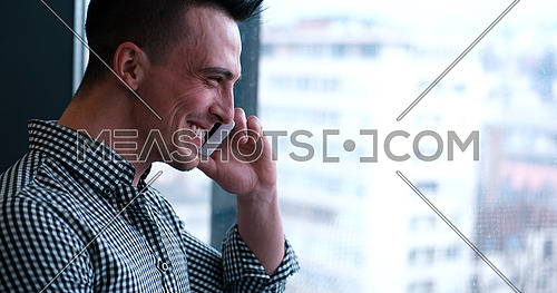 laughing man talking on the phone in office interior
