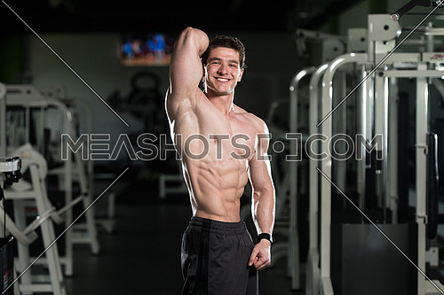 Portrait Of A Young Physically Fit Man Showing His Well Trained Abdominal Muscles - Muscular Athletic Bodybuilder Fitness Model Posing After Exercises