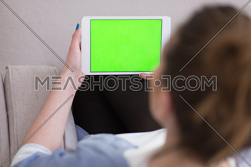young happy woman on sofa using tablet computer at luxury home