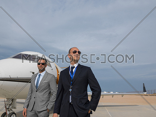 portrait of two successful middle eastern businessman in front of private airplane