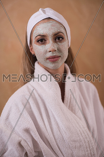 Spa Woman applying Facial Mask  Beauty Treatments  Close up portrait of beautiful girl with a towel on her head applying facial mask