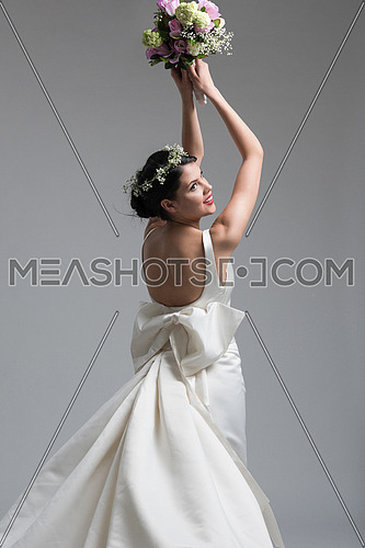 Young attractive bride with the a bouquet of flowers isolated on white background.