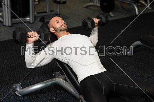 Muscular Man Doing Exercise For Chest With Dumbbells
