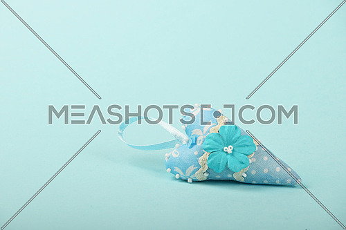 One small textile heart with mulberry paper flower and ribbon on tender blue background