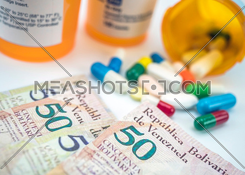 Medicines next to banknotes of Venezuela, shady deal of medication in full crisis of country of Latin America, conceptual image