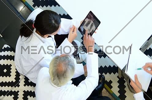 top shot -  middle eastern doctors discussing x-ray on tablet