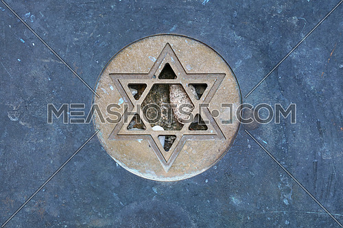 Metal Star of David (Magen David) Jewish symbol at gravestone, close up