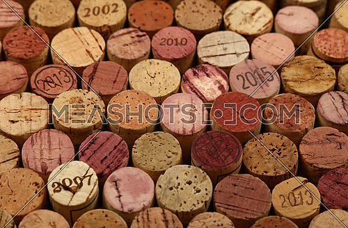 Close up background pattern of many assorted stacked used red wine corks, high angle view