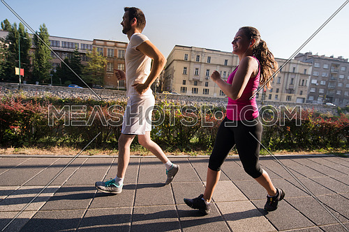urban sports, healthy young couple jogging  in the city at sunny morning