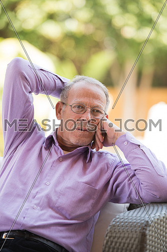 portrait of an elderly middle eastern man to enjoy the sunny summer morning at the pool