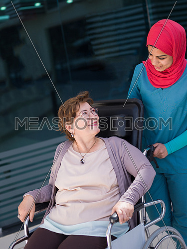 older sick woman in wheelchair with young nurse at  hospital