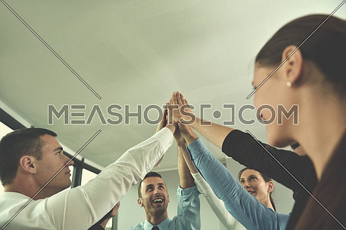 business people group joining hands and representing concept of friendship and teamwork,  low angle view