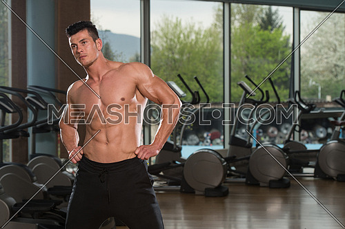 Young Man Stretching Before Exercising In Fitness Center Healthy Lifestyle Concept