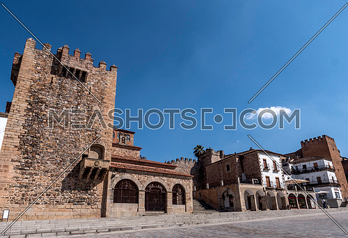 Caceres, Spain - july 13, 2018: Main square of the city, to the right monument called "Torre de Bujaco", Arab building of square plant erected on Roman ashlars, Caceres, Spain