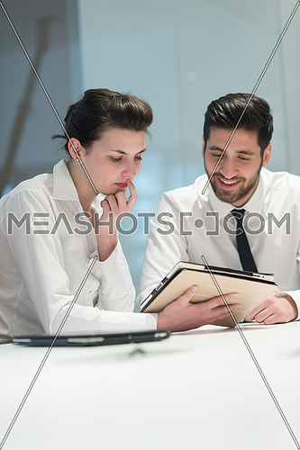 Young couple working together on tablet  computer. Teamwork, help, support concept.  Business group  at modern startup office meeting room interior working online on project plans.