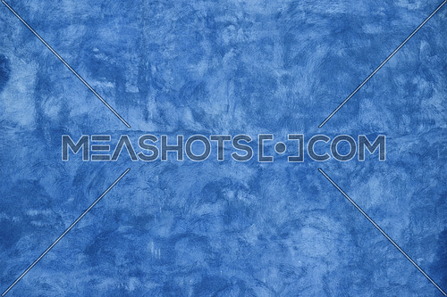 Grunge blue faded uneven old aged daub plaster wall texture background with stains and paint strokes, close up