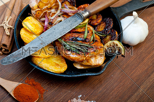 roasted grilled BBQ chicken breast with herbs and spices rustic style on iron skillet