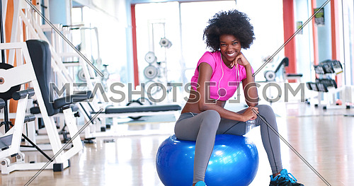 young Athletic healthy black woman resting during workout in gym