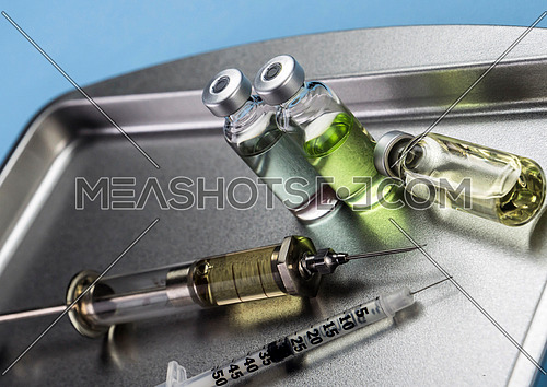 Several vials and syringe in laboratory, conceptual image