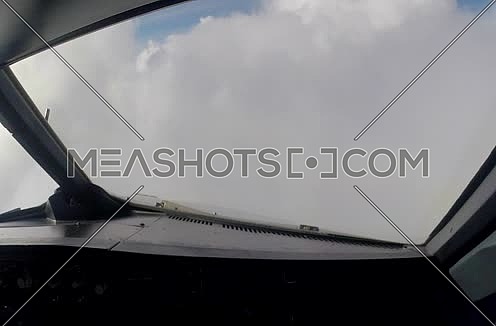 inside cockpit shot for plane flying through clouds 