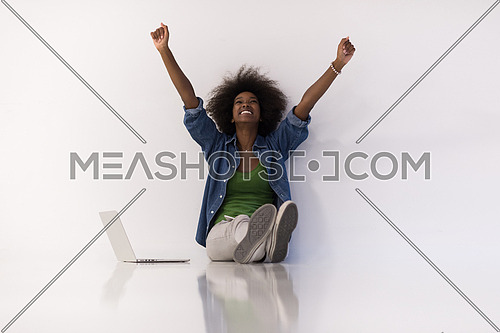 Portrait of happy young african american woman sitting on floor with laptop