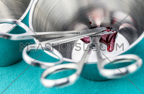 Scissors surgical soaked with blood on a tray metal in an operating theater, composition horizontal, conceptual image