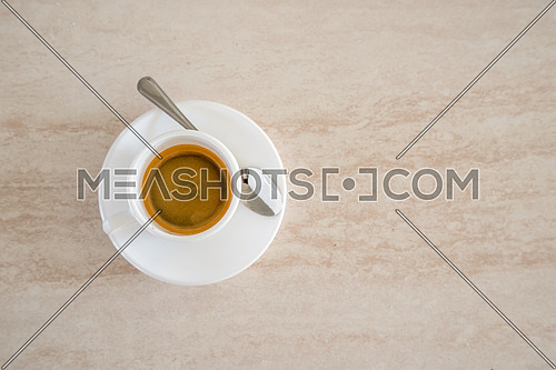 Top view of white cup of coffee with metal spoon,background and copy space.