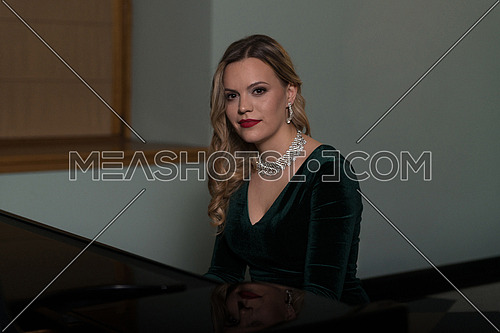 Young Artist in Green Velvet Evening Dress Playing at the Old Wooden Piano Classical Sonata by Gentle Candlelight