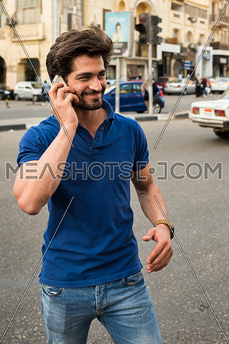 young man talking in mobile phone in the street in korba area at day