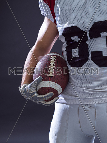 Portrait of a strong muscular American Football Player isolated on gray