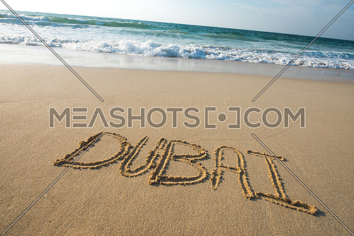 Sea shore written on the sand Dubai