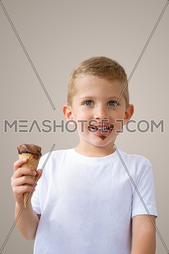 Baby boy kid hold chocolate ice cream in waffles cone isolated on beige background with free text copy space