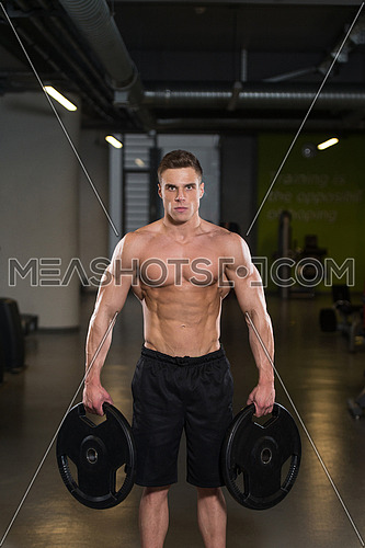 Portrait Of A Physically Fit Man Holding Weights In Hand