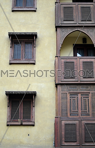 Front side of an old Islamic style  building with a wooden windows and balconies