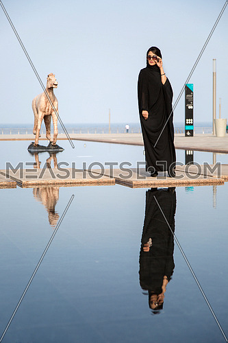 Saudi lady standing next to lake in Jeddah cornice
