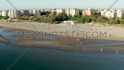 Aerial shot of sandy beach with umbrellas and gazebos.Summer vacation concept.Lido Adriano town,Adriatic coast, Emilia Romagna,Italy.
