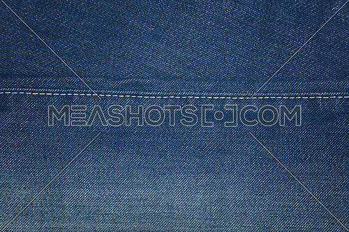 Dark indigo blue washed cotton jeans denim texture background with stitching seam edge line, close up