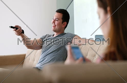 couple sitting in seperate sofas at home