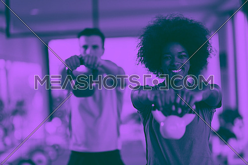 healthy couple  workout with weights lifting  dumbbels at  crossfit gym african  american woman with afro hairstyle duo tone filter