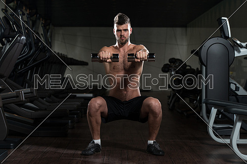 Young Man Performing Dumbbell Squats - One Of The Best Bodybuilding Exercise For Legs
