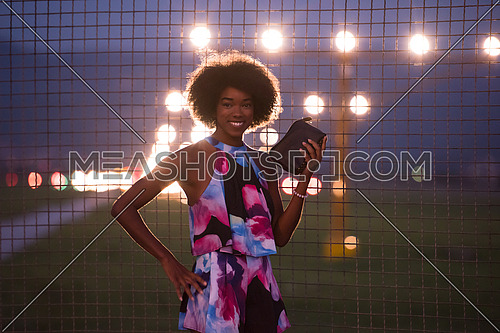 portrait of a young beautiful African American women on a warm summer night  in summer dress with a smile on her face