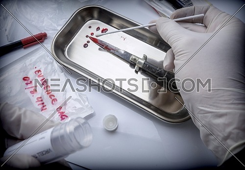 Scientist examines tests of cutting weapon of crime in a laboratory, conceptual image