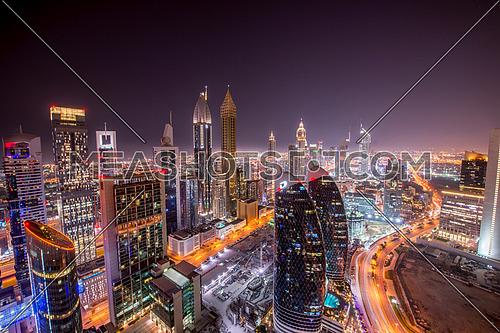 Dubai At night DIFC area in downtown showing sheikh zayed road and emirates towers